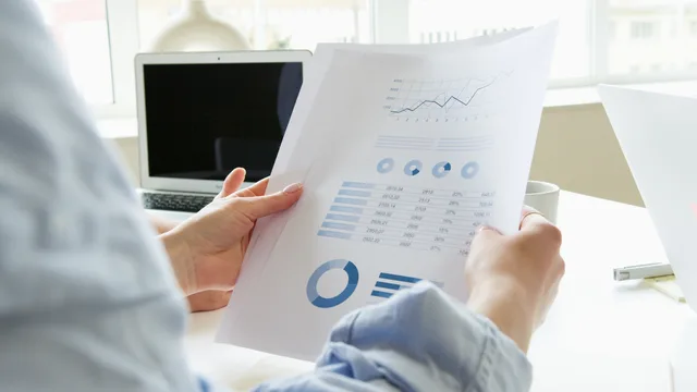 Close-up of a person analyzing business charts and graphs indoors. When to refresh the source list behind your local SEO market outlook